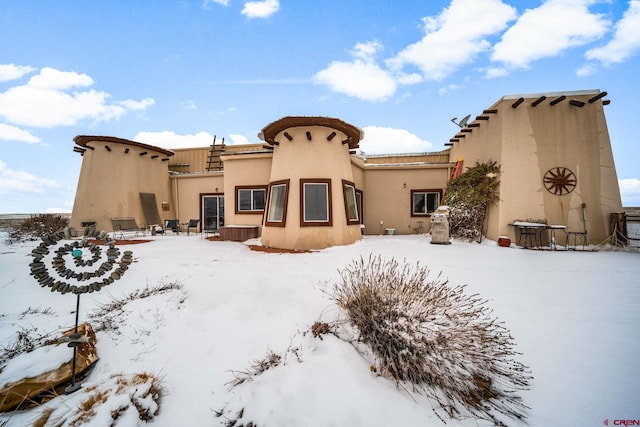 view of snow covered back of property