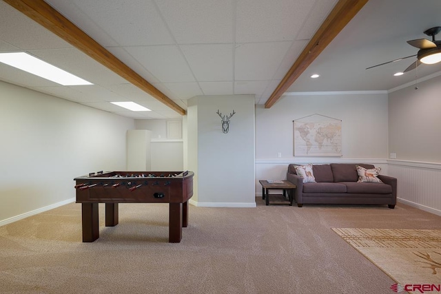 recreation room featuring a drop ceiling, ornamental molding, ceiling fan, and carpet flooring