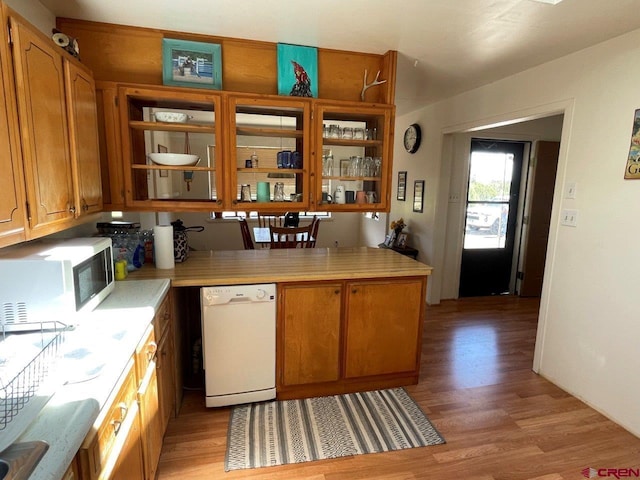 kitchen featuring white dishwasher, light hardwood / wood-style flooring, and kitchen peninsula