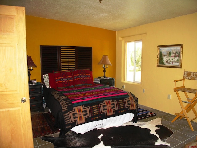 bedroom with tile patterned flooring and a textured ceiling