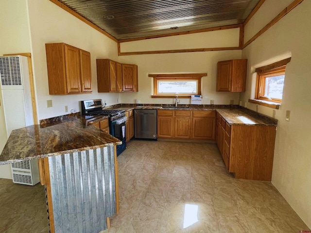 kitchen with sink, dark stone counters, ornamental molding, kitchen peninsula, and stainless steel appliances