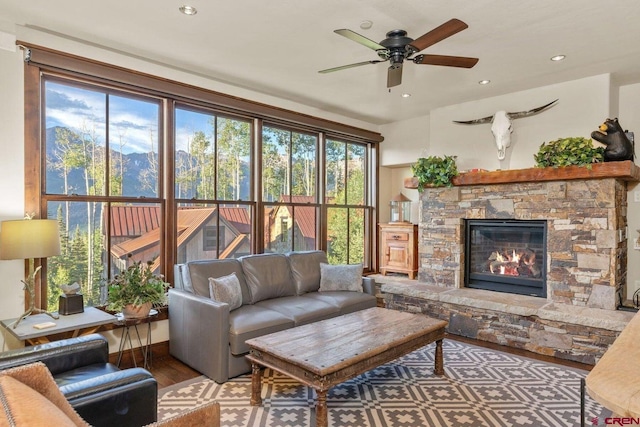 living room with ceiling fan, a fireplace, and hardwood / wood-style floors