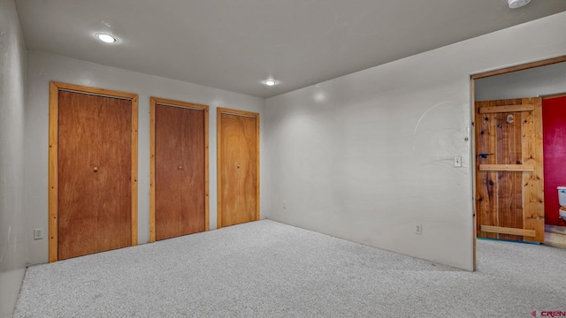 unfurnished bedroom featuring carpet and two closets