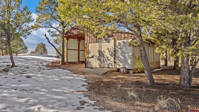 view of snowy exterior with an outbuilding