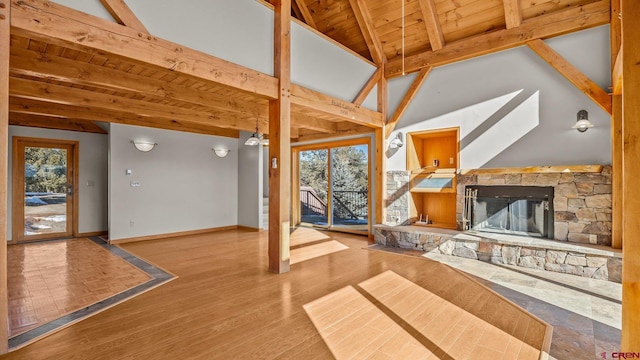 living room with wood ceiling, a fireplace, light hardwood / wood-style floors, and lofted ceiling with beams