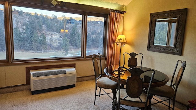 sitting room with lofted ceiling, a wall mounted air conditioner, and light colored carpet