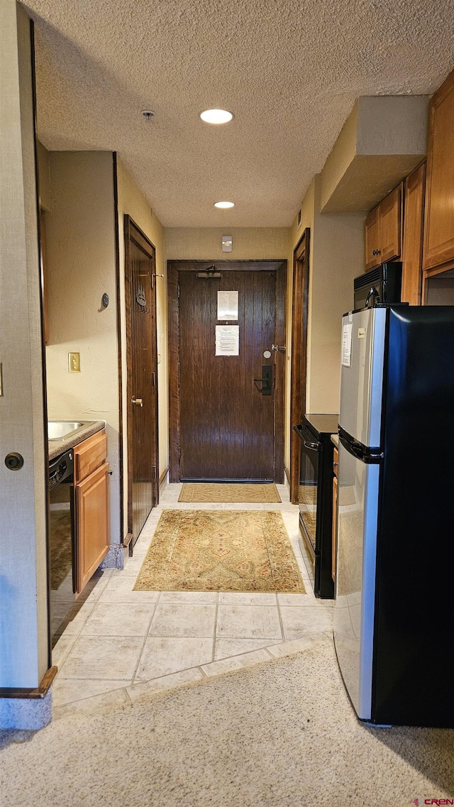 kitchen with a textured ceiling and black appliances