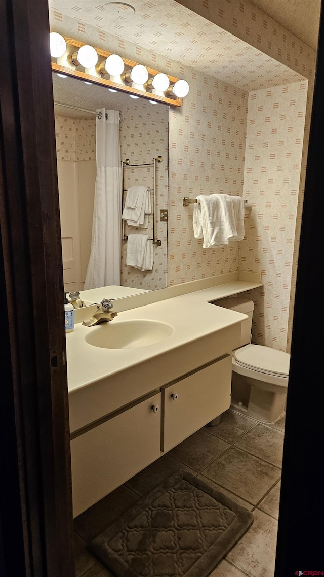 bathroom with walk in shower, tile patterned floors, vanity, and toilet