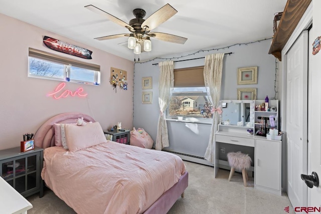 bedroom with ceiling fan, baseboard heating, and a closet