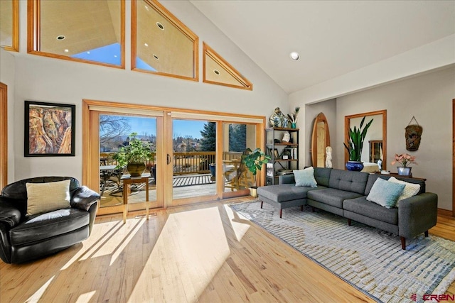 living room with french doors, high vaulted ceiling, and light wood-type flooring