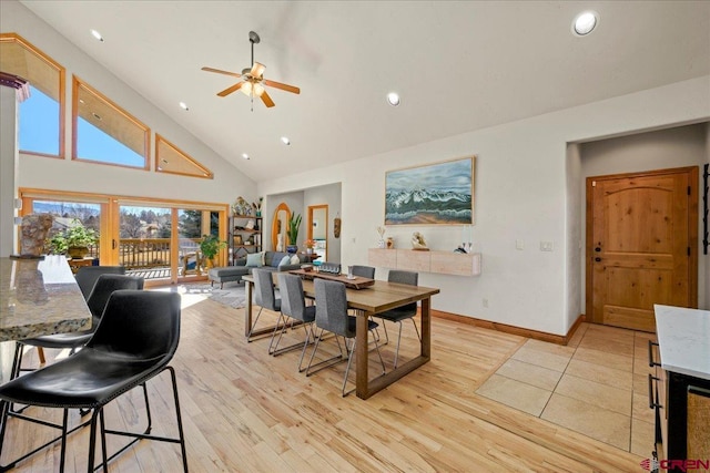 dining area with ceiling fan, high vaulted ceiling, and light hardwood / wood-style floors