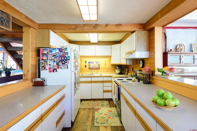 kitchen featuring white cabinetry, white appliances, beam ceiling, and dark wood-type flooring