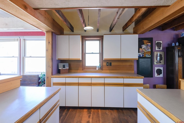 kitchen featuring dark hardwood / wood-style floors, beam ceiling, and white cabinets