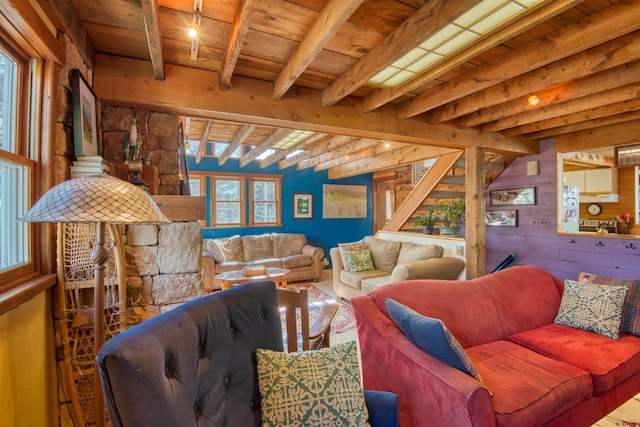 living room with beamed ceiling, wooden walls, and wooden ceiling