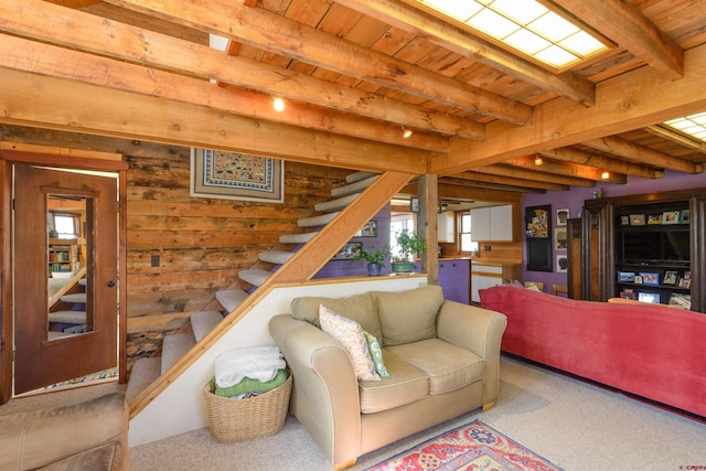 carpeted living room featuring beamed ceiling, wooden ceiling, and wood walls