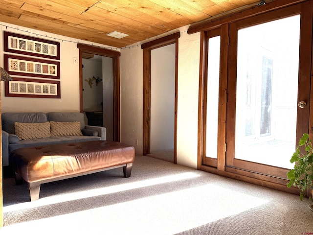 interior space featuring wood ceiling and carpet