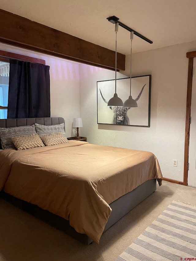 carpeted bedroom with beam ceiling