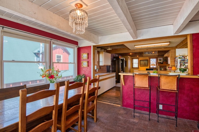 dining room featuring beamed ceiling, plenty of natural light, wooden ceiling, and a notable chandelier