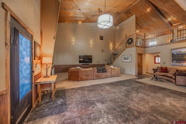 living room featuring plenty of natural light, carpet flooring, and a high ceiling