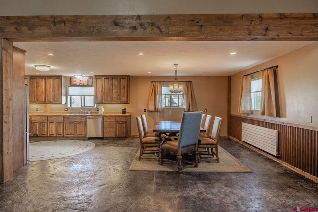 dining space with an inviting chandelier, a healthy amount of sunlight, radiator heating unit, and beam ceiling