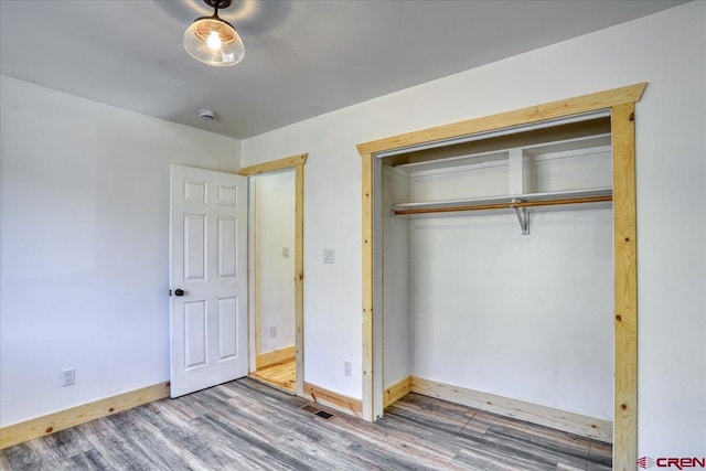 unfurnished bedroom with hardwood / wood-style floors and a closet