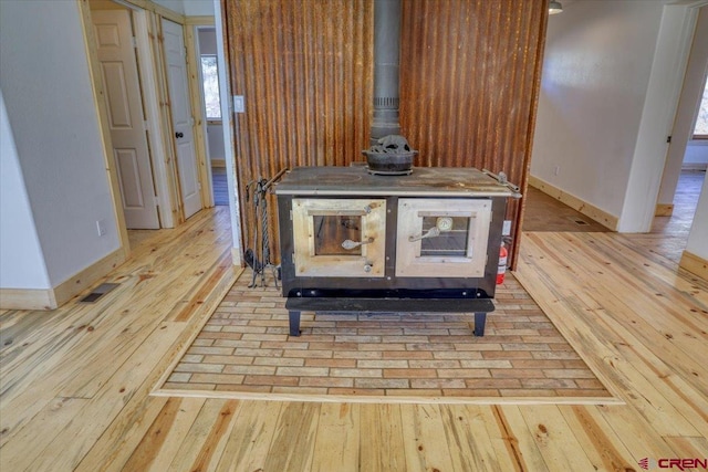 interior details with hardwood / wood-style flooring and a wood stove