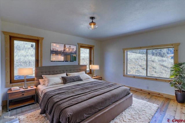 bedroom with a textured ceiling and light wood-type flooring