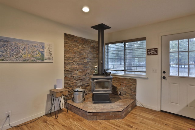 living room with light hardwood / wood-style flooring and a wood stove