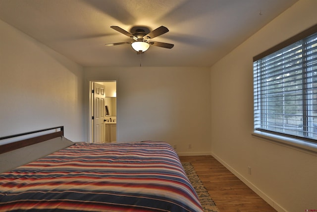 bedroom with connected bathroom, wood-type flooring, and ceiling fan