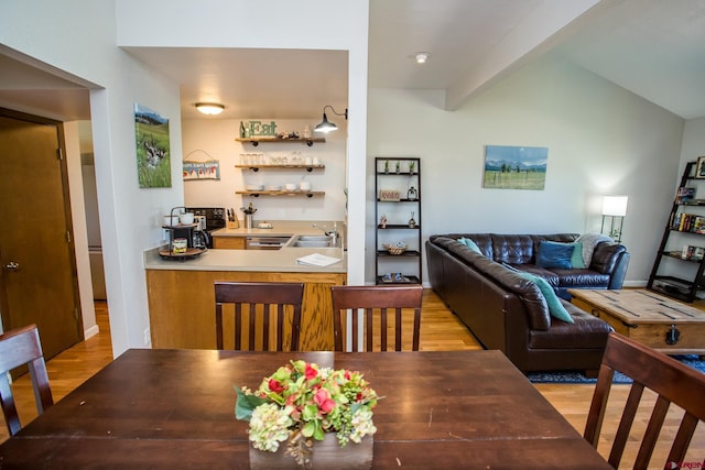 dining area featuring beam ceiling and light wood-type flooring