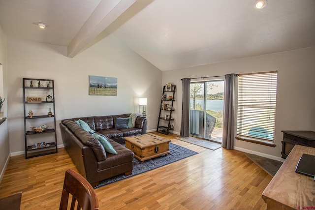 living room featuring lofted ceiling with beams and light wood-type flooring