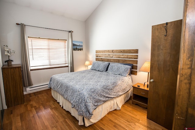 bedroom featuring lofted ceiling, dark hardwood / wood-style flooring, and baseboard heating