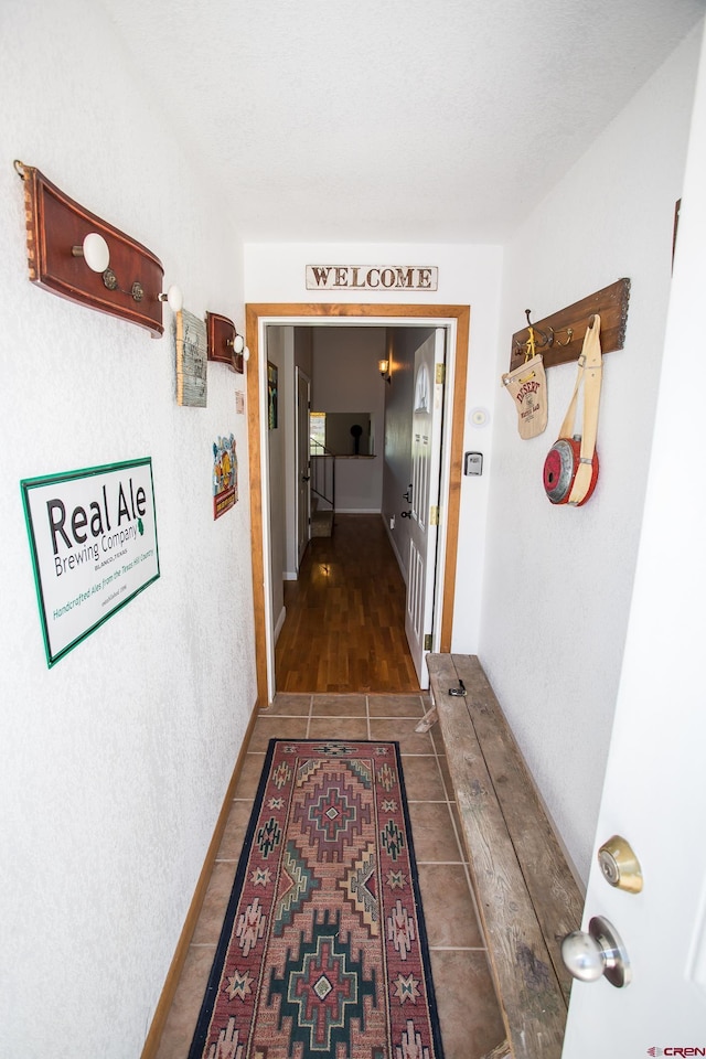 hall with dark tile patterned floors