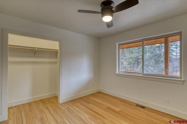 unfurnished bedroom with ceiling fan, a closet, light hardwood / wood-style flooring, and a textured ceiling