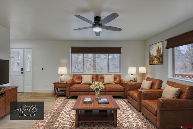 living room featuring ceiling fan and light hardwood / wood-style floors