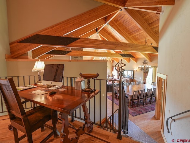 dining space with high vaulted ceiling, an inviting chandelier, beam ceiling, and light hardwood / wood-style flooring