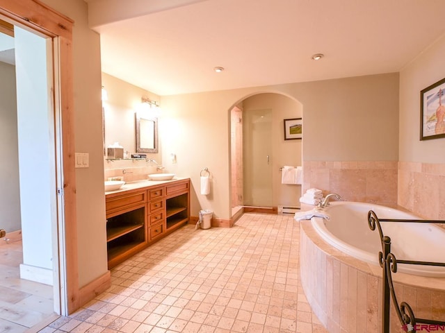 bathroom with a baseboard radiator, vanity, and separate shower and tub