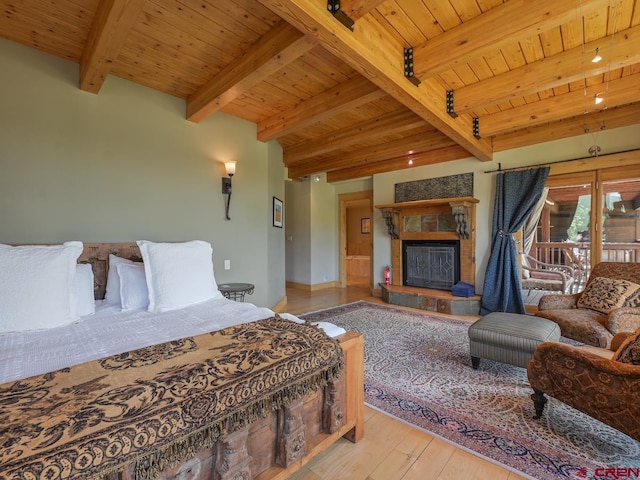 bedroom featuring wood ceiling, access to outside, light wood-type flooring, beamed ceiling, and a tiled fireplace