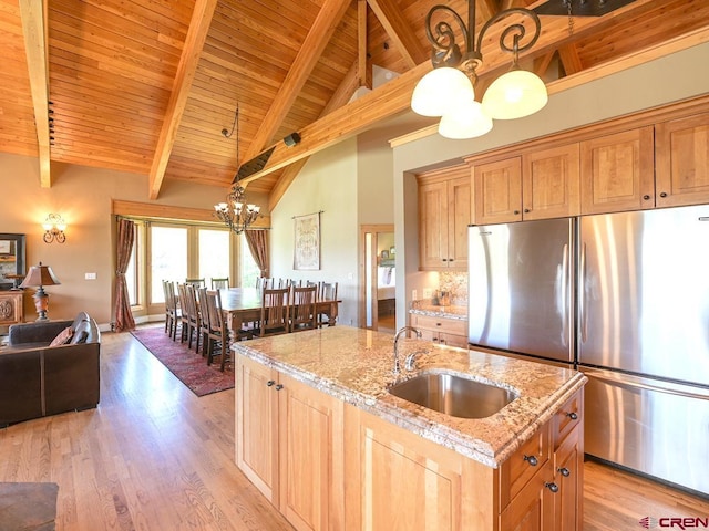 kitchen featuring sink, pendant lighting, stainless steel fridge, and light wood-type flooring