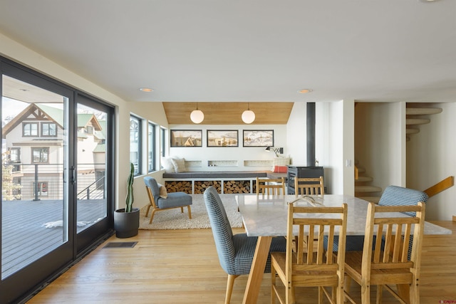 dining area with vaulted ceiling and light hardwood / wood-style flooring