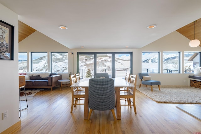 dining room featuring lofted ceiling and light hardwood / wood-style flooring