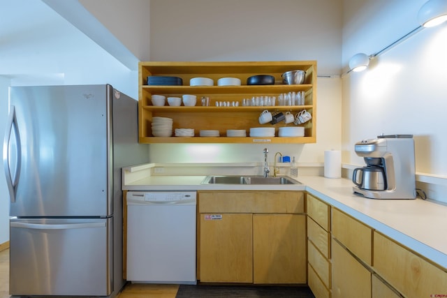 kitchen with sink, light brown cabinets, stainless steel refrigerator, light wood-type flooring, and white dishwasher