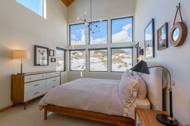 carpeted bedroom featuring a towering ceiling and a notable chandelier