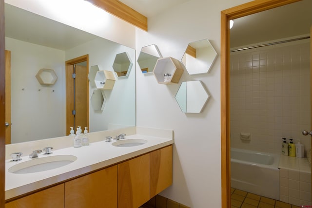 bathroom with tiled shower / bath combo, vanity, and tile patterned floors