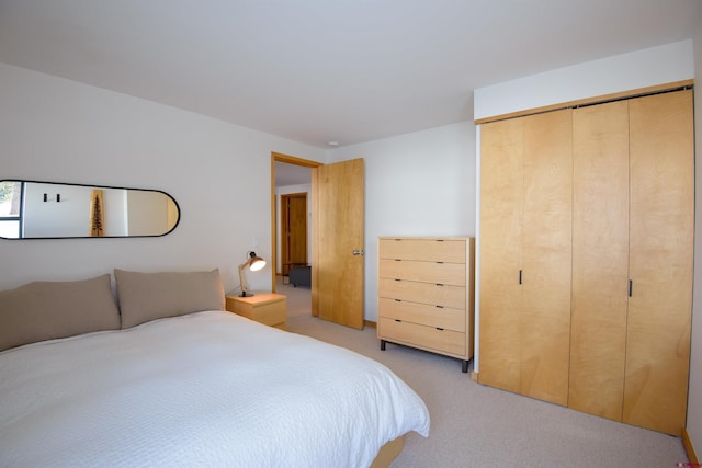 bedroom featuring light colored carpet and a closet