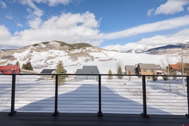 snow covered deck with a mountain view