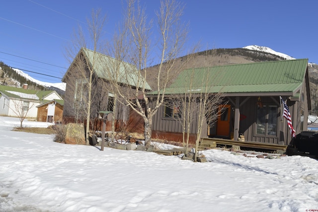 snow covered rear of property with a mountain view