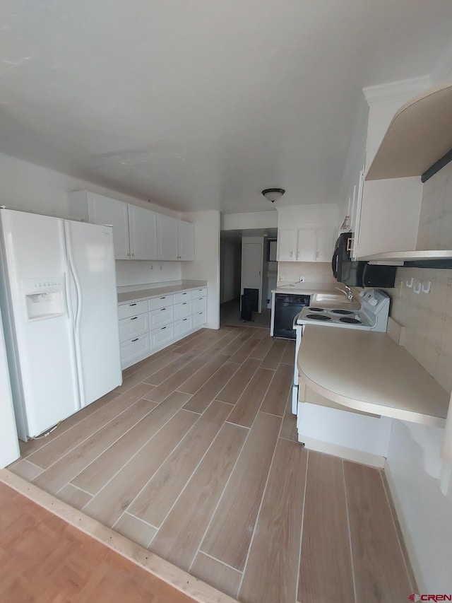 kitchen featuring sink, white appliances, and white cabinets