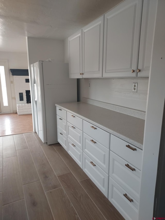 kitchen with white fridge with ice dispenser and white cabinets