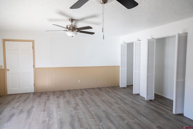 unfurnished bedroom with ceiling fan, wood-type flooring, and a textured ceiling